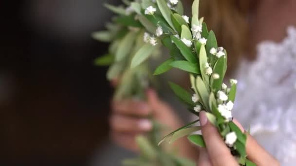 невеста держит в руках грациозный венок из цветущей мирты - Кадры, видео