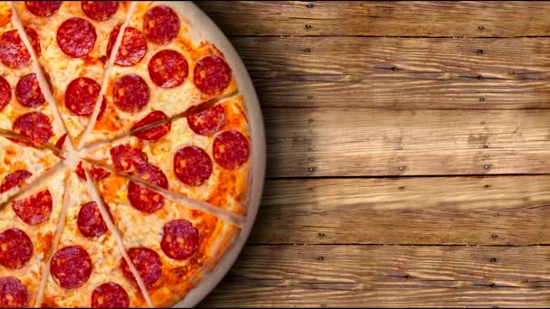 A video of the background pepperoni pizza on a wooden table. Footage. - Footage, Video