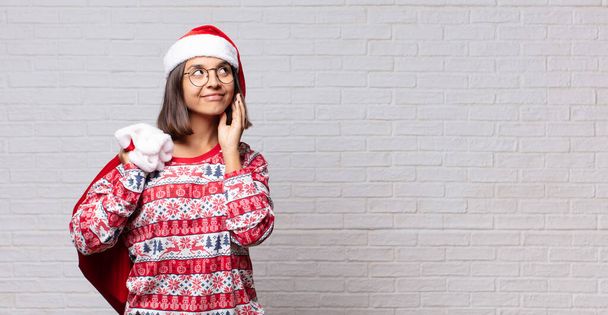 young woman christmas concept against brick wall - Photo, Image