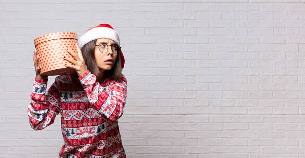 young woman christmas concept against brick wall - Foto, Bild