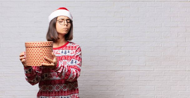 young woman christmas concept against brick wall - Фото, изображение