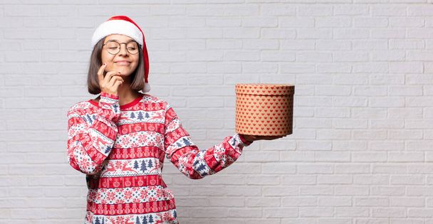 young woman christmas concept against brick wall - Foto, imagen