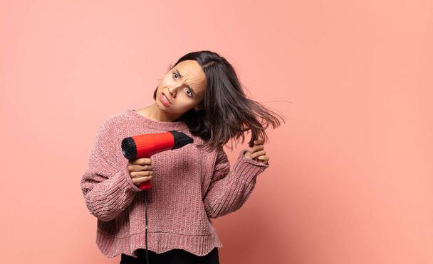 hispanic pretty woman with a hair dryer - Foto, afbeelding