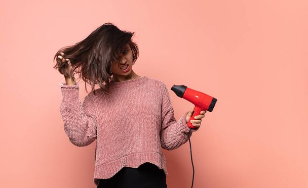 hispanic pretty woman with a hair dryer - Foto, Imagen