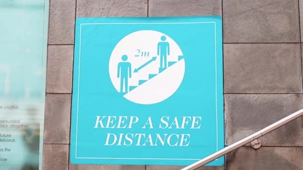 Señal azul de "Distancia segura" junto a las escaleras - Imágenes, Vídeo