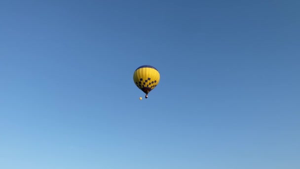 Πολύχρωμα αερόστατα θερμού αέρα πετούν στον ηλιόλουστο πρωινό μπλε ουρανό. Πτήση με δυνατότητα ελιγμών. Ταξίδια, περιπέτεια, φεστιβάλ. - Πλάνα, βίντεο