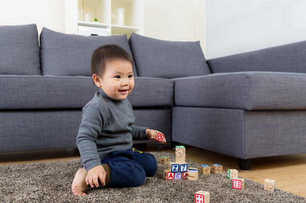 Aasialainen pieni poika pelata puinen lelu lohko
 - Valokuva, kuva