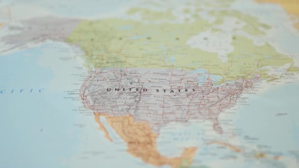 Hand setzt einen Reisepass der Vereinigten Staaten von Amerika auf eine nordamerikanische Landkarte - Filmmaterial, Video