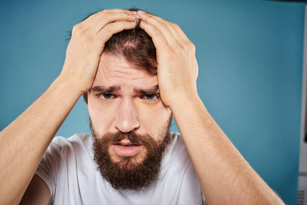 Bearded man displeased facial expression emotions close-up blue background white t-shirt - Foto, Imagem