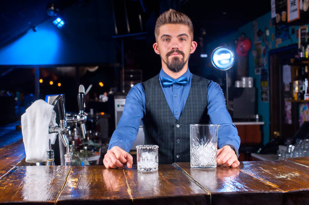 Doświadczony barman robi koktajl przy barze. - Zdjęcie, obraz