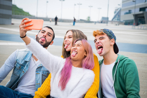 Grupo de inquilinos haciendo caras y bromeando juntos mientras una videollamada con sus amigos - Grupo de amigos de vacaciones tomando una selfie para recordar este momento especial - Foto, imagen