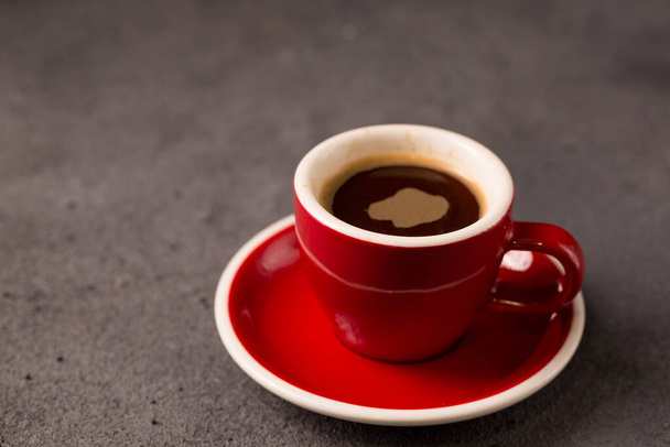 Black brewed coffee in a red coffee cup - Fotoğraf, Görsel