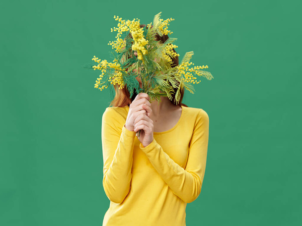 žena s kyticí mimózy květiny a zelené izolované pozadí  - Fotografie, Obrázek