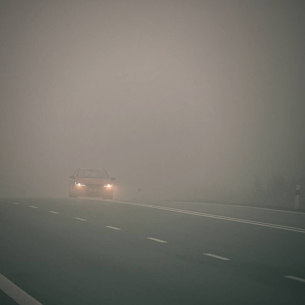 Mal tiempo de conducción - nebuloso camino de campo nebuloso. Autopista - tráfico por carretera. Tiempo de invierno. - Foto, imagen
