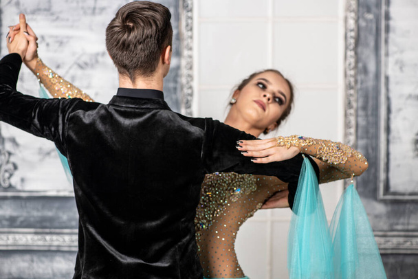 mladý pár ve večerních tanečních kostýmech tanec tango v tanečním sále - Fotografie, Obrázek