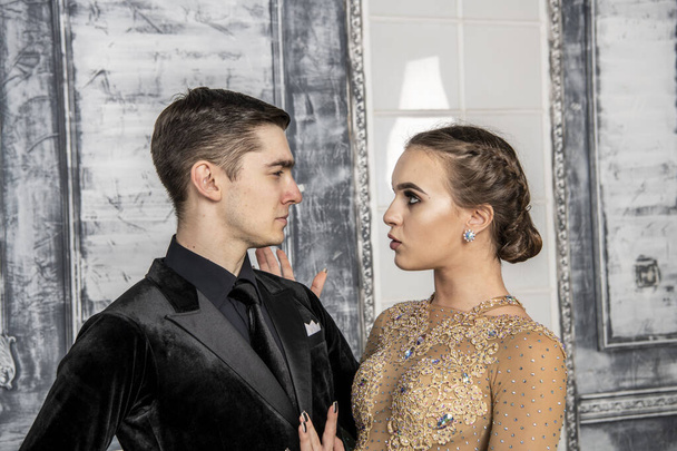 jeune couple en costumes de danse du soir posant dans la salle de danse - Photo, image