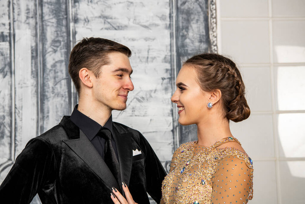 pareja joven en trajes de baile de noche posando en el salón de baile - Foto, imagen