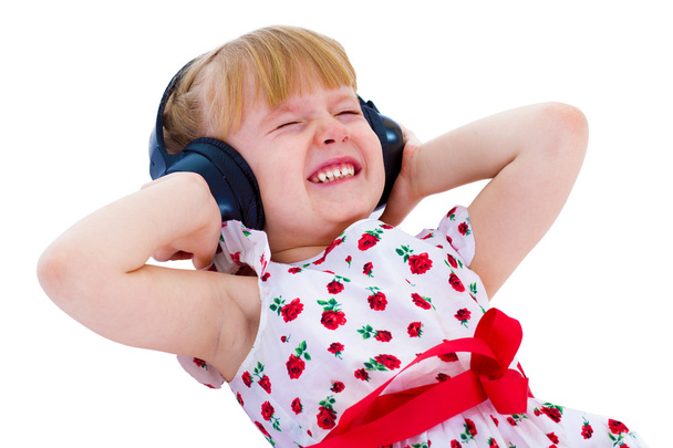 Charming little girl loves to listen to music through headphones - Fotografie, Obrázek