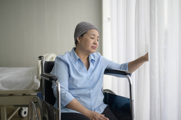 A depressed and hopeless Asian cancer patient woman wearing head scarf in hospital. - Φωτογραφία, εικόνα