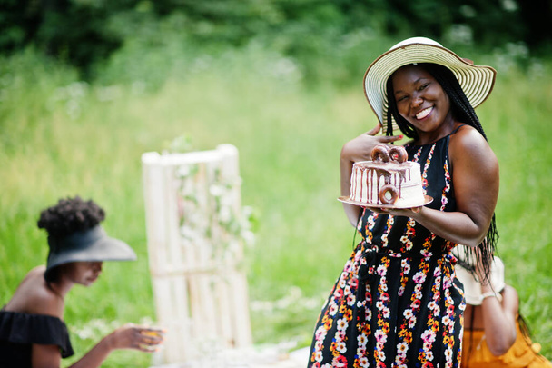Group of african american girls celebrating birthday party and hold cake outdoor with decor. - Photo, Image