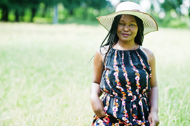 Portrait of gorgeous african american woman 20s in summer hat posing at green grass in park. - Valokuva, kuva