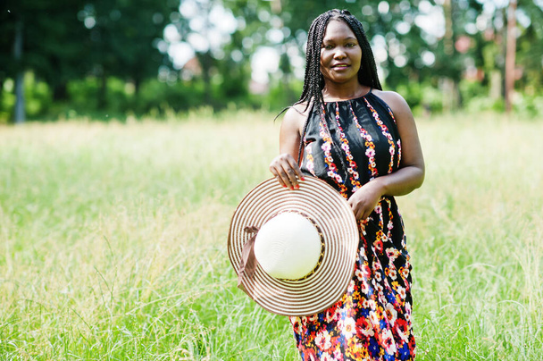 Portrait of gorgeous african american woman 20s in summer hat posing at green grass in park. - Fotografie, Obrázek
