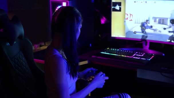 Mujer joven jugando un juego en línea en el club de juego - se da la vuelta y jugar con una goma de mascar - Metraje, vídeo