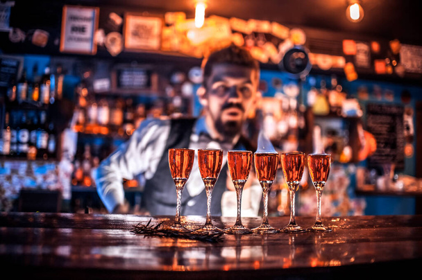 Joven barman demuestra sus habilidades sobre el mostrador en el bar - Foto, Imagen