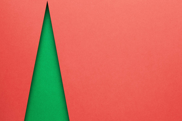 Minimal christmas concept with green shape of christmas tree. Empty room for text on red background. Top view - Φωτογραφία, εικόνα