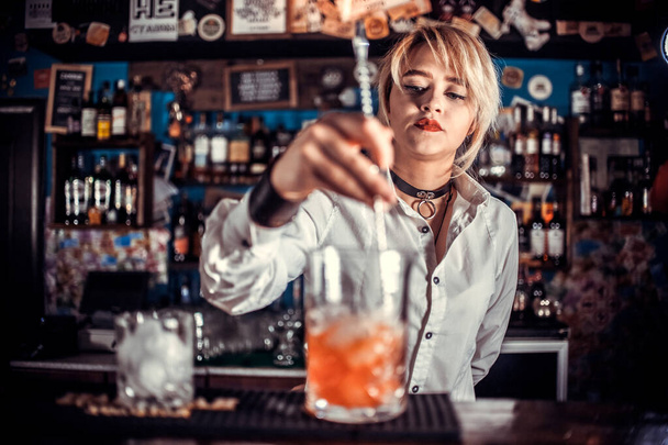 Дівчина бармен змішує коктейль у тапочці
 - Фото, зображення