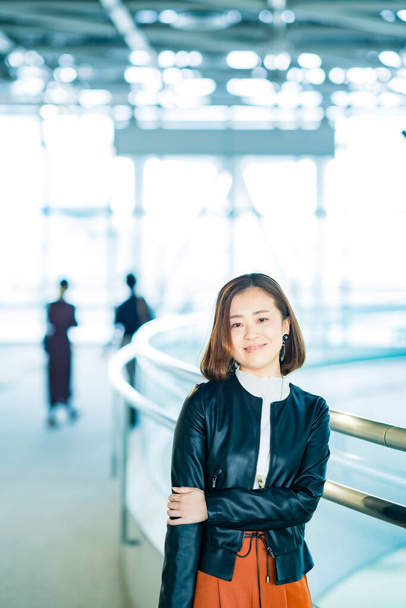 Casualmente vestida mujer de negocios asiática en el espacio de edificio de oficinas - Foto, imagen
