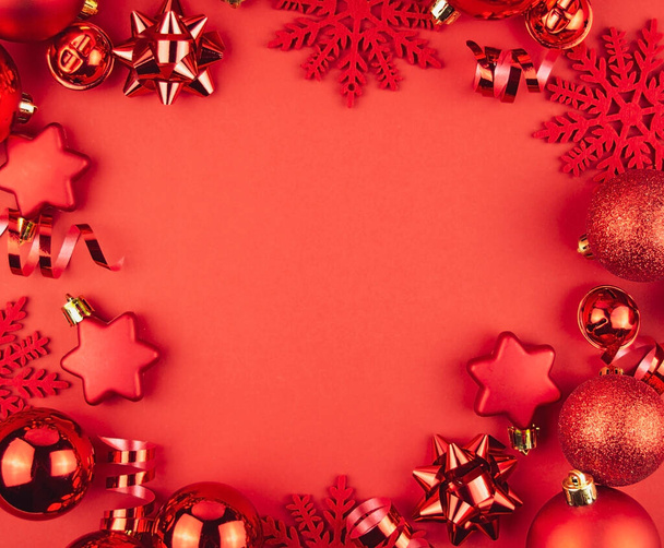 赤い背景に赤いボール、蛇紋岩と星のクリスマスのフレーム。クリスマスの飾りだ。クリスマスの背景。バナーモックアップ、はがき。平置きだ。スペースのコピー. - 写真・画像