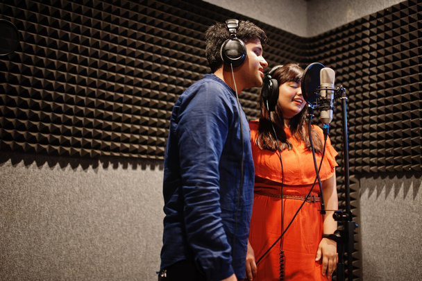 Young asian duet singers with microphone recording song in record music studio. - Фото, зображення
