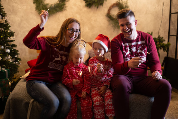 Famiglia allegra con scintille che celebrano il Natale a casa - Foto, immagini