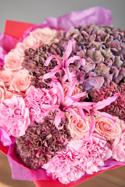 Roze en paarse bloemen. Herfst boeket van gemengde bloemen in glazen vaas op houten tafel. Het werk van de bloemist in een bloemenwinkel. Verse snijbloem. - Foto, afbeelding