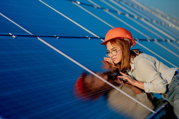 Beautiful young engineer standing near solar panels outdoors, Green Energy Concept. - Photo, Image