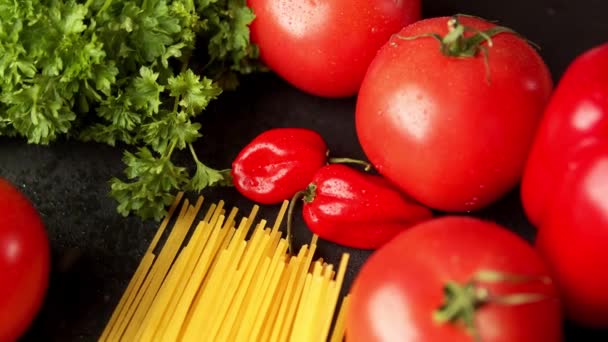 tomaten met peterselie en pasta op een zwarte achtergrond - Video