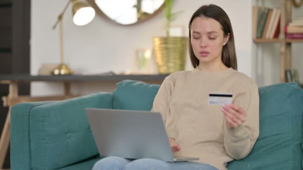 Online nákupní úspěch na notebooku od mladé ženy na pohovce - Záběry, video