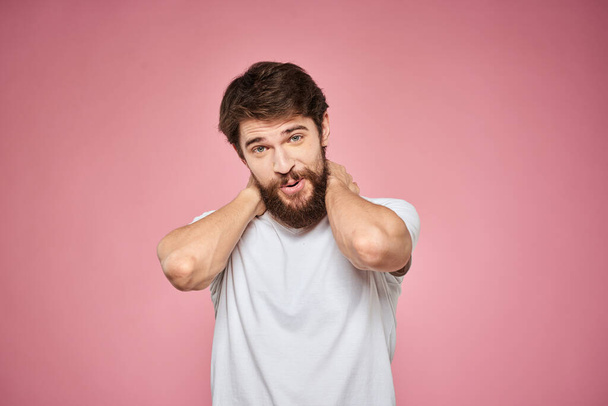 陽気な髭の男の白いTシャツの感情クロップドビューピンクの背景 - 写真・画像