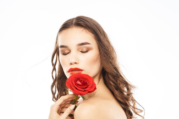 Kobieta z nagimi ramionami i czerwony róż wieczorem makijaż lekkie tło - Zdjęcie, obraz