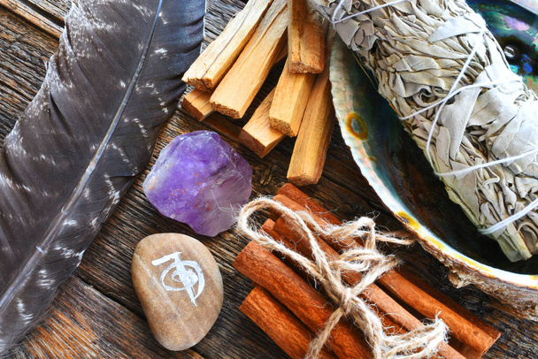 Une image de vue de dessus de bâton de tache de sauge blanche avec des cristaux de guérison, plume sacrée et symbole de reiki. - Photo, image