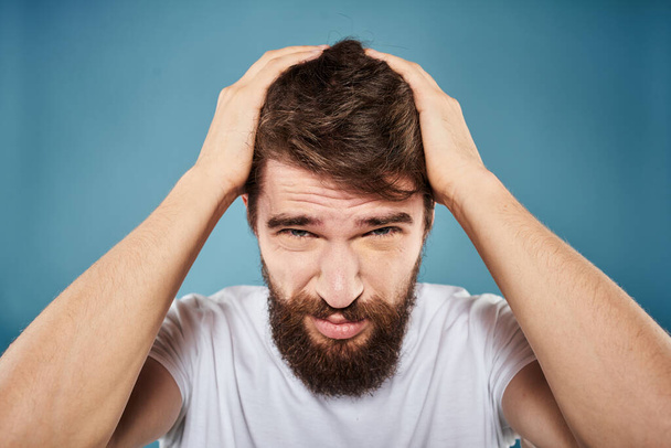 Homem barbudo desagradado expressão facial emoções close-up azul fundo branco t-shirt - Foto, Imagem