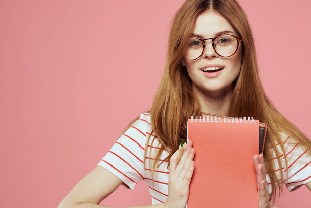 kaunis nainen opiskelija tilalla kirjoja oppilaitoksen ele kädet vaaleanpunainen tausta Kopioi tilaa - Valokuva, kuva