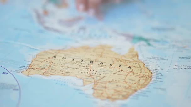 Человек, помещающий три пальца на красочную и расплывчатую карту Австралии - Кадры, видео