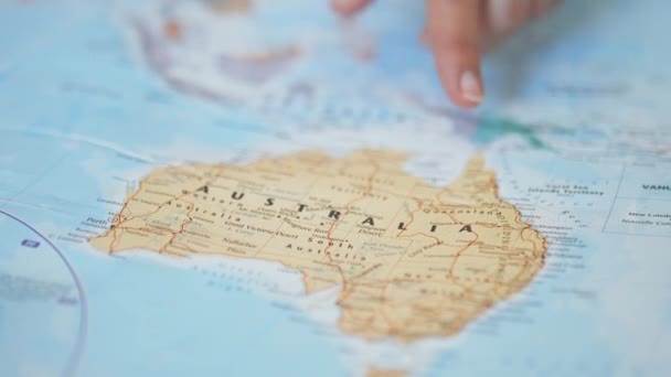Mão de pessoa se movendo em torno da Austrália em um mapa colorido e embaçado - Filmagem, Vídeo