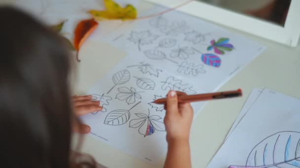 Dziewczynka kolorowanki różne rodzaje liści na papierze z długopisem - Materiał filmowy, wideo