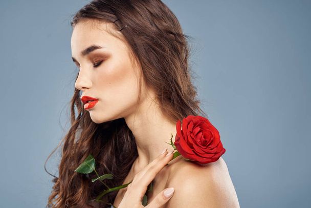 femme avec une rose dans ses mains épaules nues soirée maquillage lèvres rouges - Photo, image