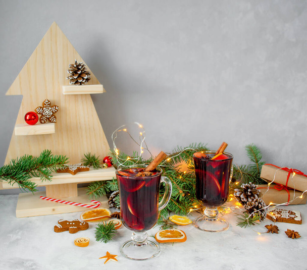 hristmas hot mulled wine with carnation, cinnamon, cardamom and anise on wooden background with Christmas decorations. New Year drinks. - Photo, Image