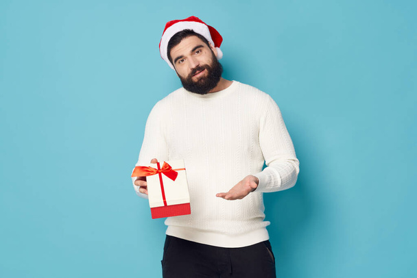 Christmas man in a sweater with a gift box in his hand New Years  - Foto, Bild