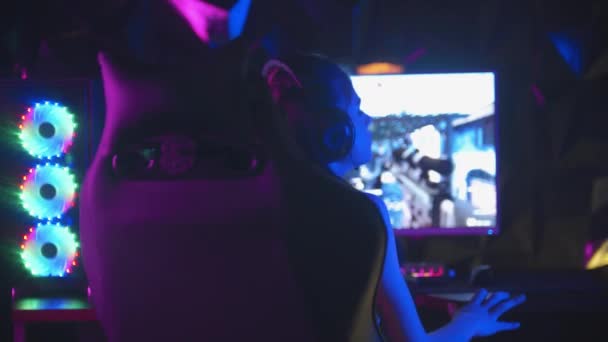 Junge Frau spielt Online-Spiel in Spielclub - regt sich auf und wendet sich mit traurigem Gesicht der Kamera zu - Filmmaterial, Video